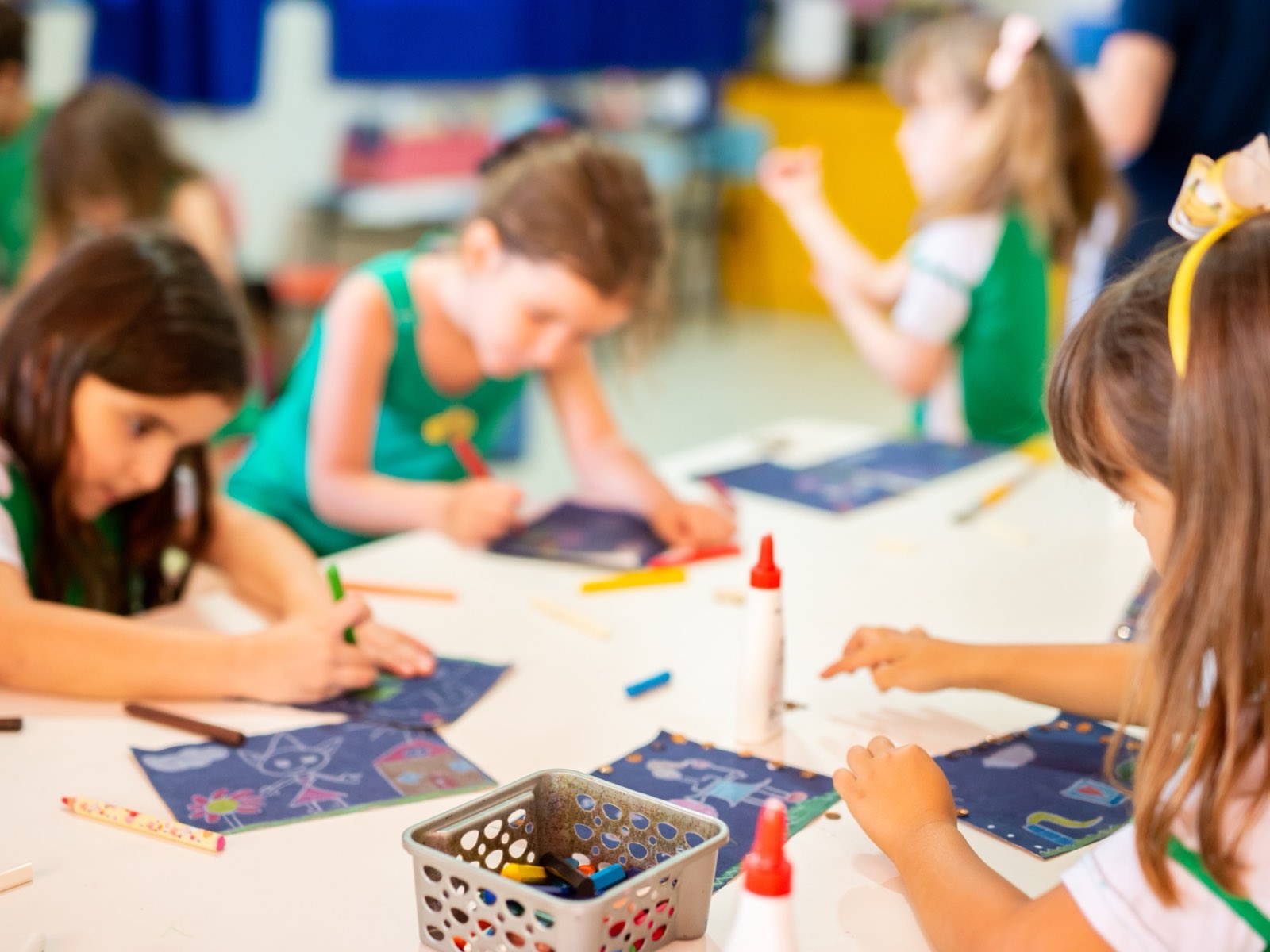 Crianças da Educação Infantil desenhando e recortando juntas na sala